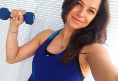 Anna Lewandowska w granatowej sportowej koszulce i ciężarkiem w ręce Anna Lewandowska w granatowej sportowej koszulce i ciężarkiem w ręce