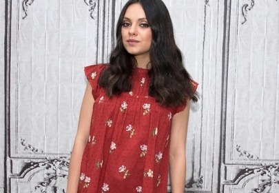 Mila Kunis na tle szarej ściany z ornamentami Mila Kunis na tle szarej ściany z ornamentami